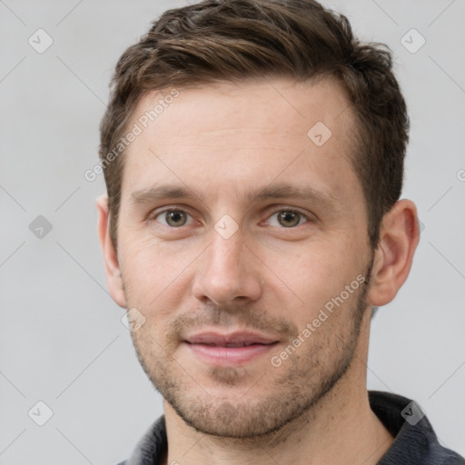 Joyful white young-adult male with short  brown hair and grey eyes