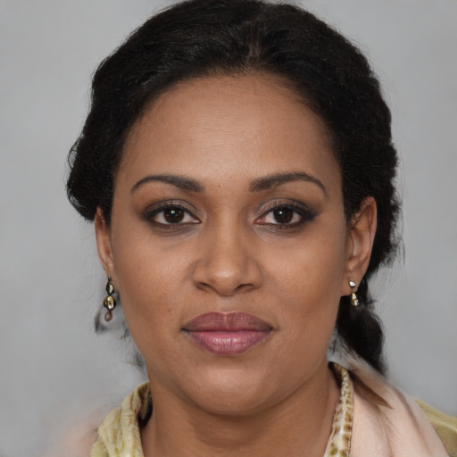 Joyful black adult female with long  brown hair and brown eyes