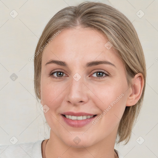 Joyful white young-adult female with medium  brown hair and grey eyes