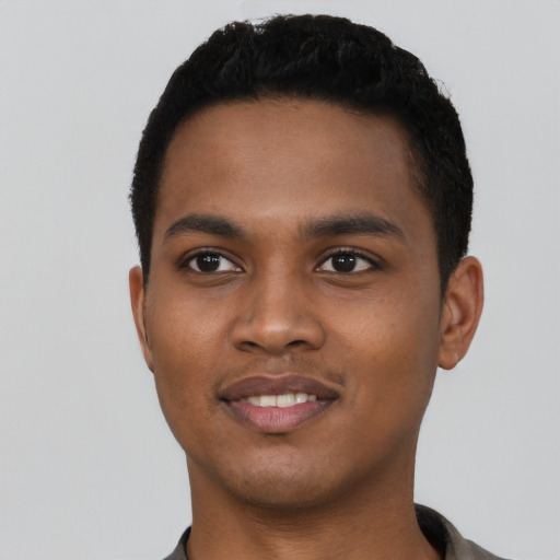Joyful black young-adult male with short  black hair and brown eyes