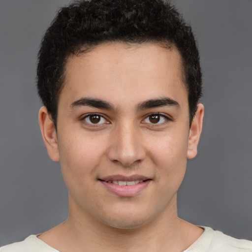 Joyful latino young-adult male with short  brown hair and brown eyes