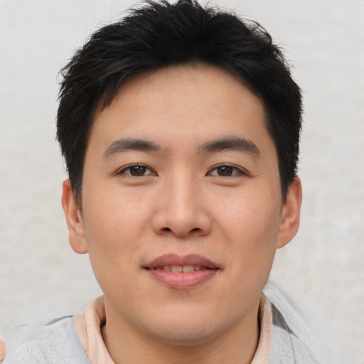 Joyful asian young-adult male with short  brown hair and brown eyes