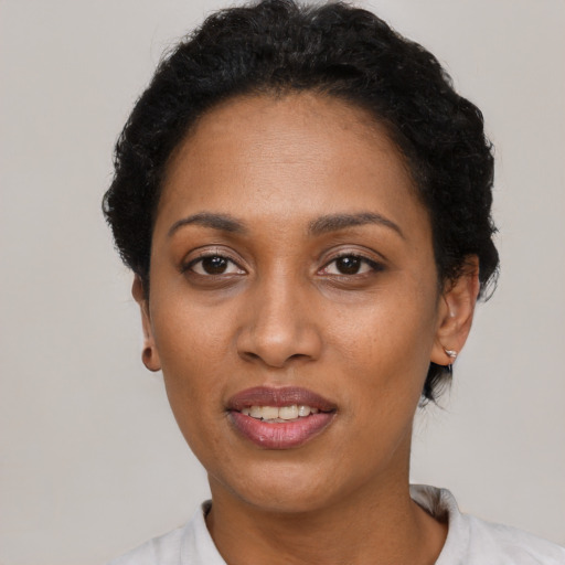 Joyful black adult female with short  black hair and brown eyes