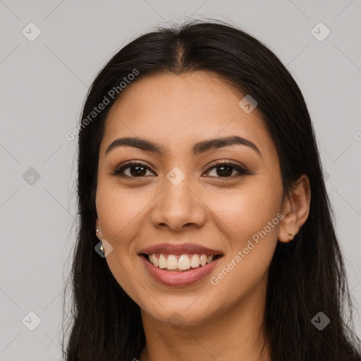 Joyful latino young-adult female with long  brown hair and brown eyes