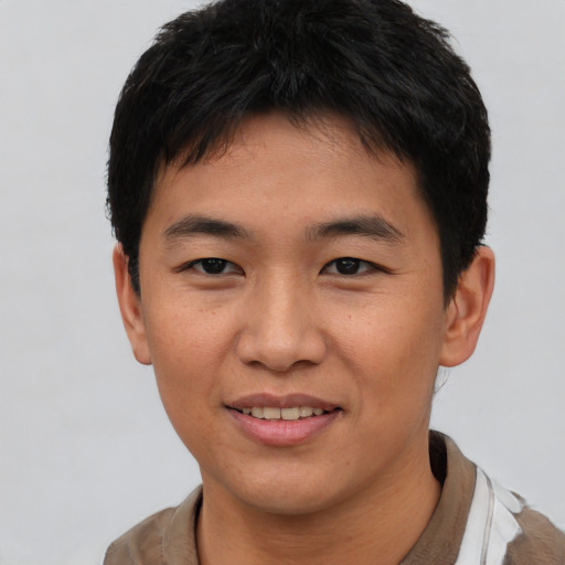 Joyful asian young-adult male with short  black hair and brown eyes