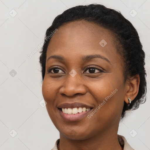 Joyful black young-adult female with long  black hair and brown eyes