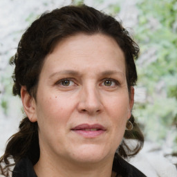 Joyful white adult female with medium  brown hair and green eyes