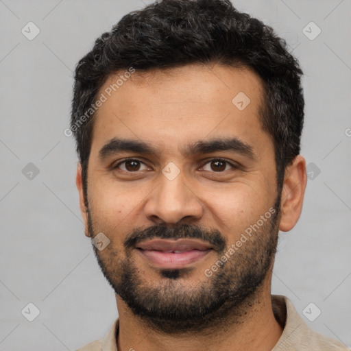 Joyful latino young-adult male with short  black hair and brown eyes