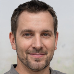 Joyful white adult male with short  brown hair and brown eyes