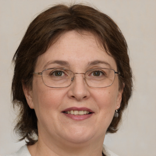 Joyful white adult female with medium  brown hair and green eyes