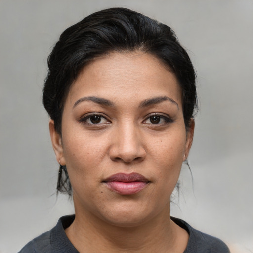 Joyful latino young-adult female with medium  brown hair and brown eyes