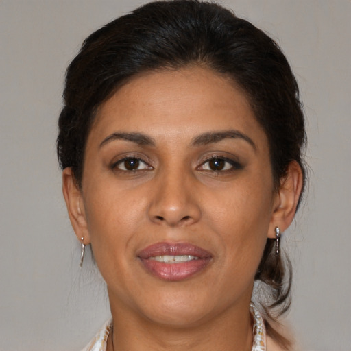 Joyful latino adult female with medium  brown hair and brown eyes