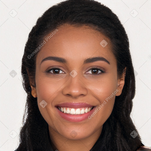 Joyful black young-adult female with long  brown hair and brown eyes