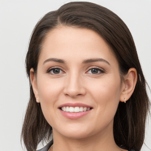 Joyful white young-adult female with long  brown hair and brown eyes