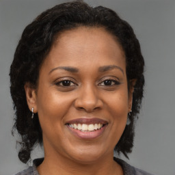 Joyful black adult female with medium  brown hair and brown eyes