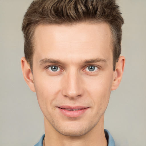 Joyful white young-adult male with short  brown hair and grey eyes