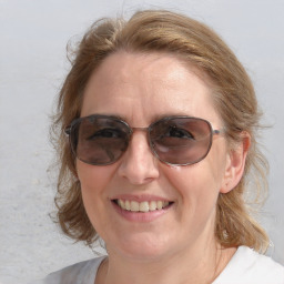 Joyful white adult female with medium  brown hair and blue eyes