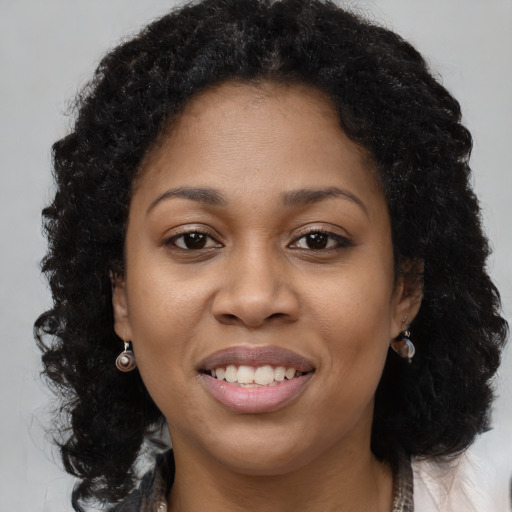 Joyful black young-adult female with long  brown hair and brown eyes