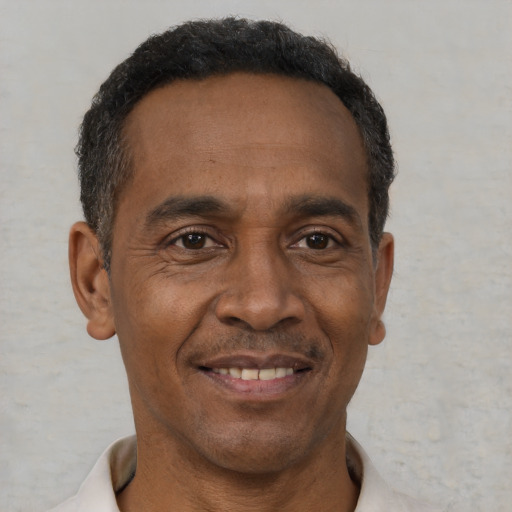 Joyful black adult male with short  brown hair and brown eyes