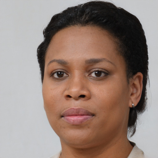 Joyful black young-adult female with short  black hair and brown eyes