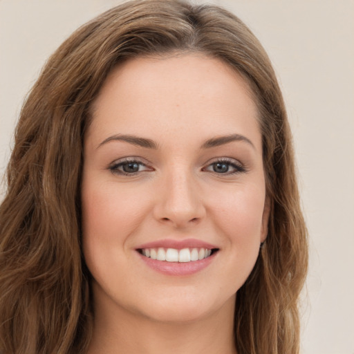 Joyful white young-adult female with long  brown hair and green eyes