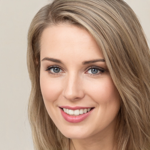 Joyful white young-adult female with long  brown hair and green eyes