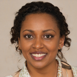 Joyful black young-adult female with medium  brown hair and brown eyes