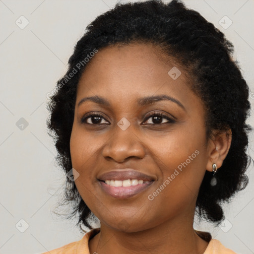 Joyful black young-adult female with long  black hair and brown eyes