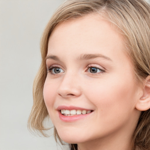 Joyful white young-adult female with long  brown hair and blue eyes