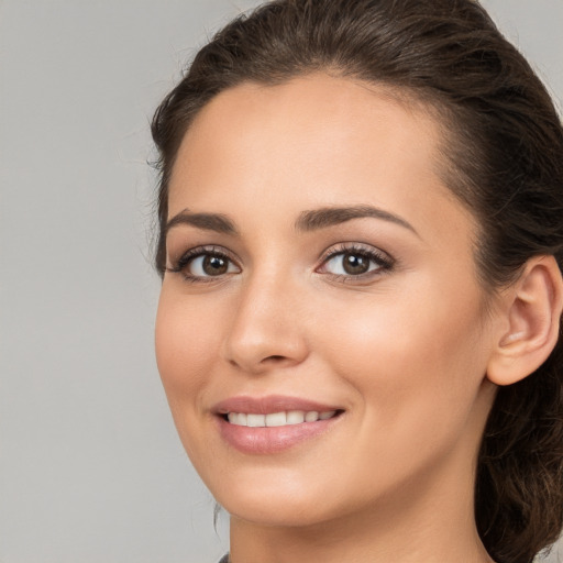 Joyful white young-adult female with long  brown hair and brown eyes