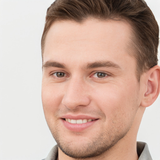 Joyful white young-adult male with short  brown hair and grey eyes