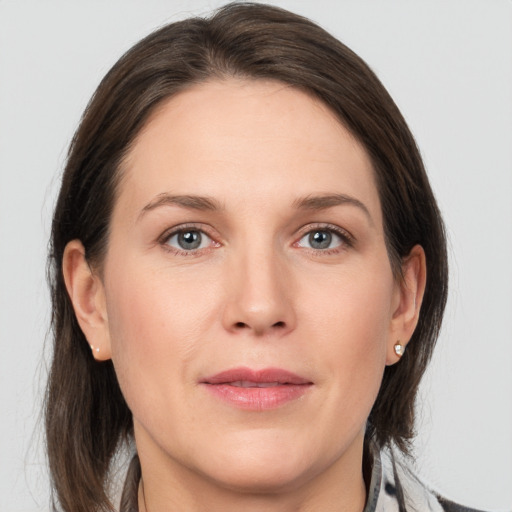 Joyful white adult female with medium  brown hair and grey eyes