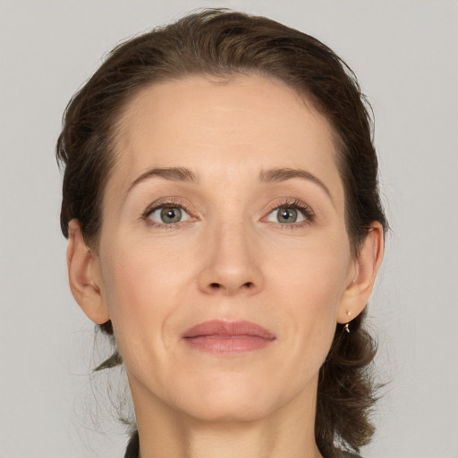 Joyful white adult female with medium  brown hair and grey eyes