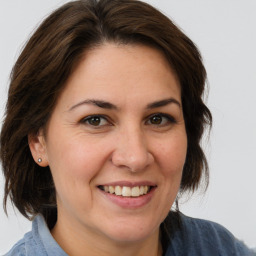 Joyful white adult female with medium  brown hair and brown eyes