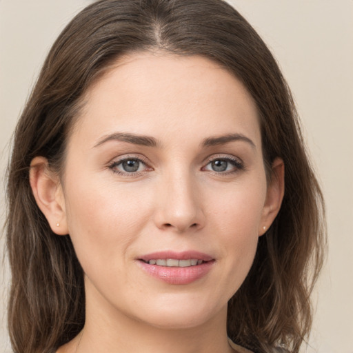 Joyful white young-adult female with medium  brown hair and grey eyes