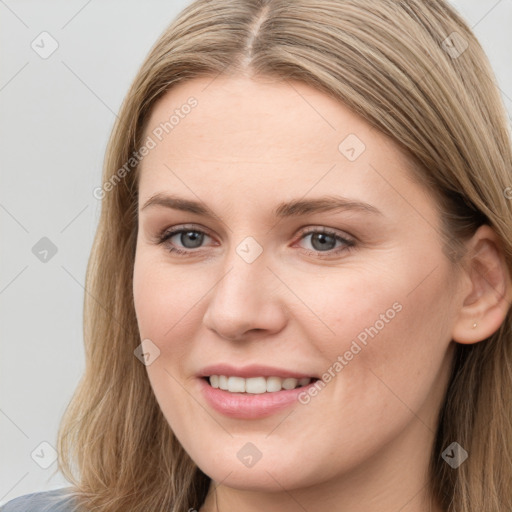 Joyful white young-adult female with long  brown hair and blue eyes