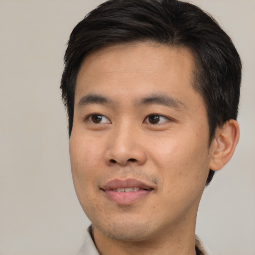 Joyful asian young-adult male with short  brown hair and brown eyes