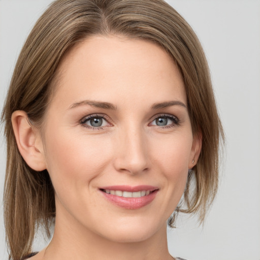 Joyful white young-adult female with medium  brown hair and grey eyes