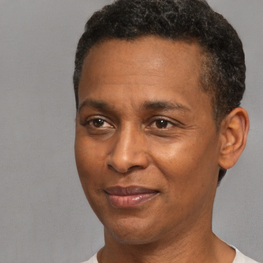 Joyful black adult male with short  black hair and brown eyes