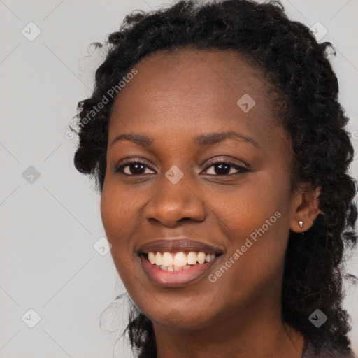 Joyful black young-adult female with long  brown hair and brown eyes