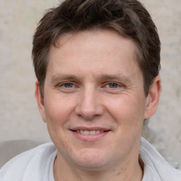 Joyful white adult male with short  brown hair and grey eyes