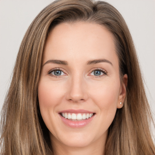 Joyful white young-adult female with long  brown hair and brown eyes