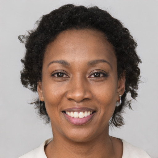 Joyful black young-adult female with short  brown hair and brown eyes
