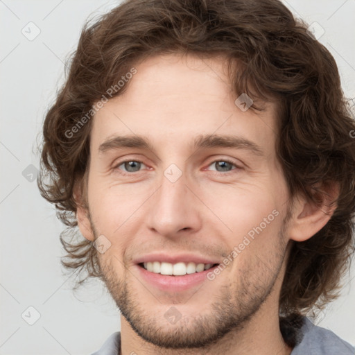 Joyful white young-adult male with medium  brown hair and grey eyes