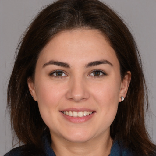 Joyful white young-adult female with long  brown hair and brown eyes