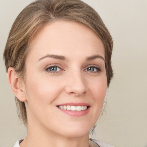 Joyful white young-adult female with medium  brown hair and grey eyes