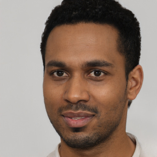 Joyful black young-adult male with short  black hair and brown eyes