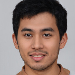 Joyful asian young-adult male with short  black hair and brown eyes