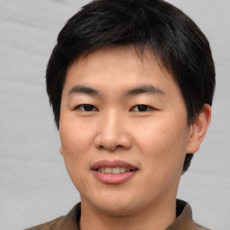 Joyful asian young-adult male with short  brown hair and brown eyes