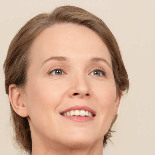 Joyful white adult female with medium  brown hair and blue eyes